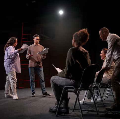 Actors in rehearsal under warm stage lights